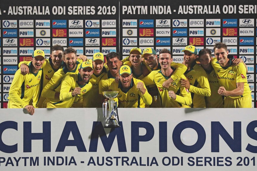 Australian cricketers gather in a huddle to celebrate winning the series against India
