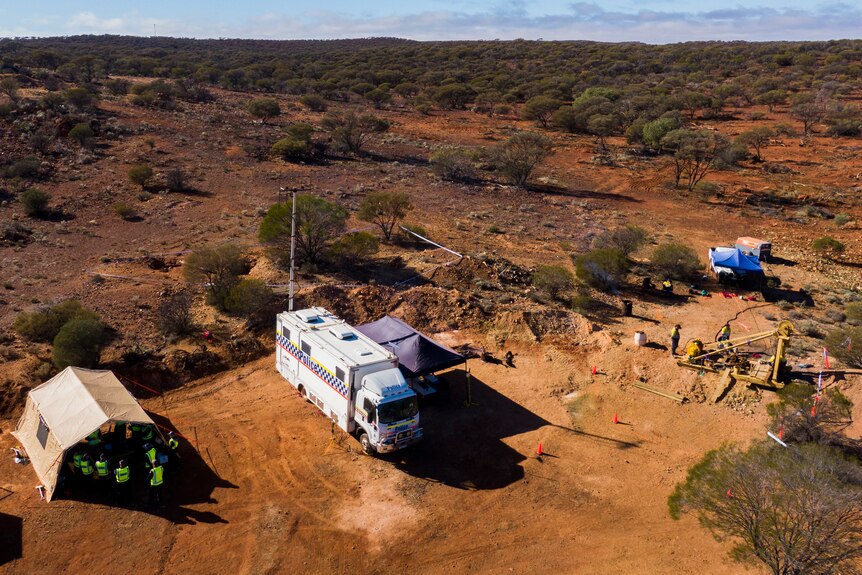 A police tent and truck pictured from above in a remote setting