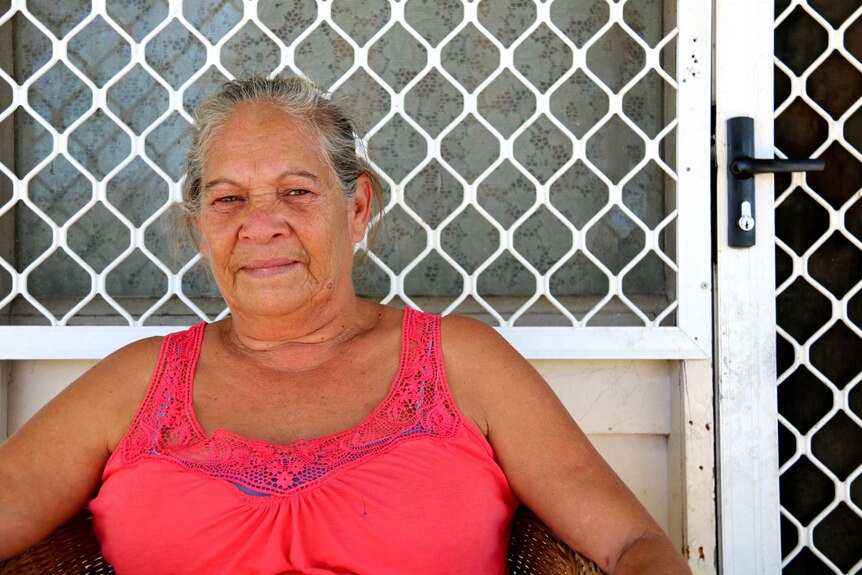 Woman sitting outside her home in Moree, NSW