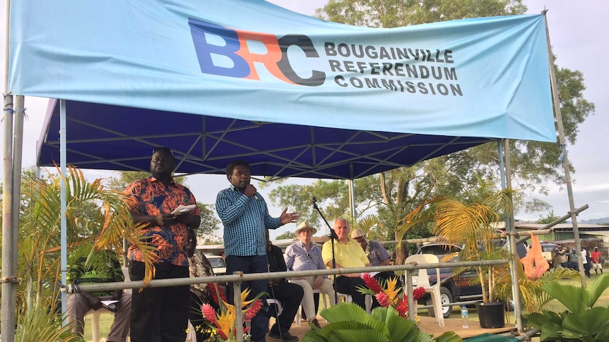 Several speakers address a crowd at an outdoor event