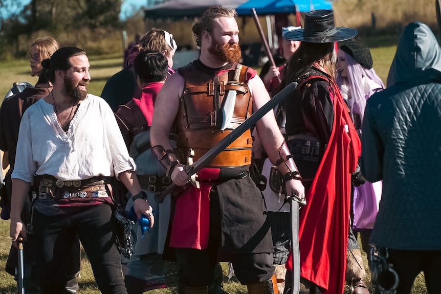 A group of people wearing warrior costumes and carrying swords.