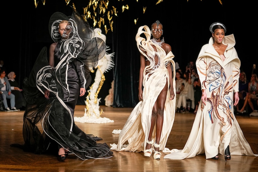 Three models wear couture by Iris van Herpen.