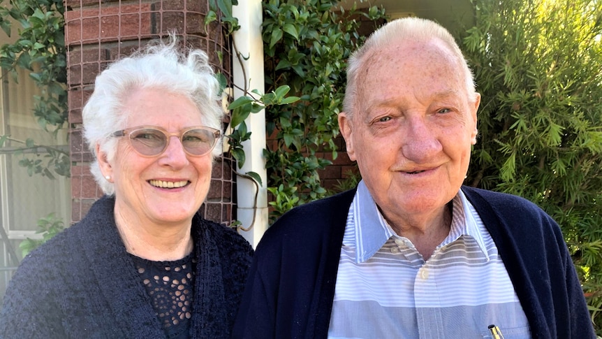 The pair stand beside each other in their garden