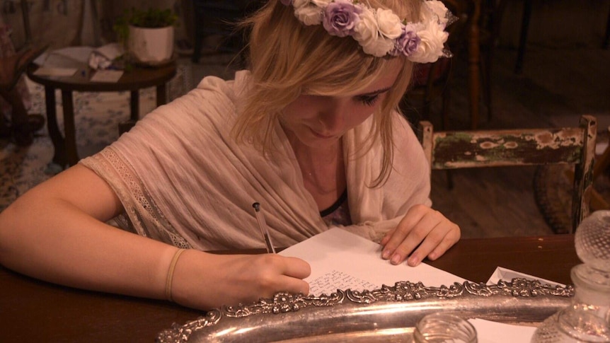 Woman with flower crown writes letter