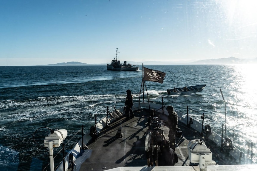 A speedboat approaches a ship with a Sea Shepherd flag raise