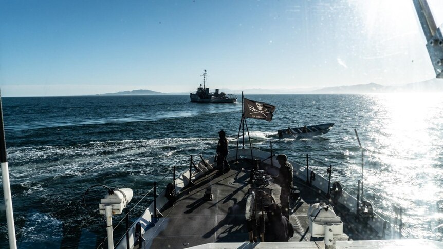 A speedboat approaches a ship with a Sea Shepherd flag raise