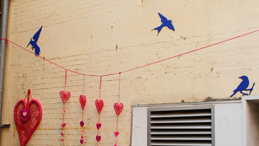 Large pink hearts on a string hang near the back entrances of shops in Brisbane's CBD. It is set to be popular for Valentines Day.