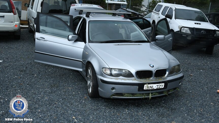 A picture of a silver BMW with the doors open.
