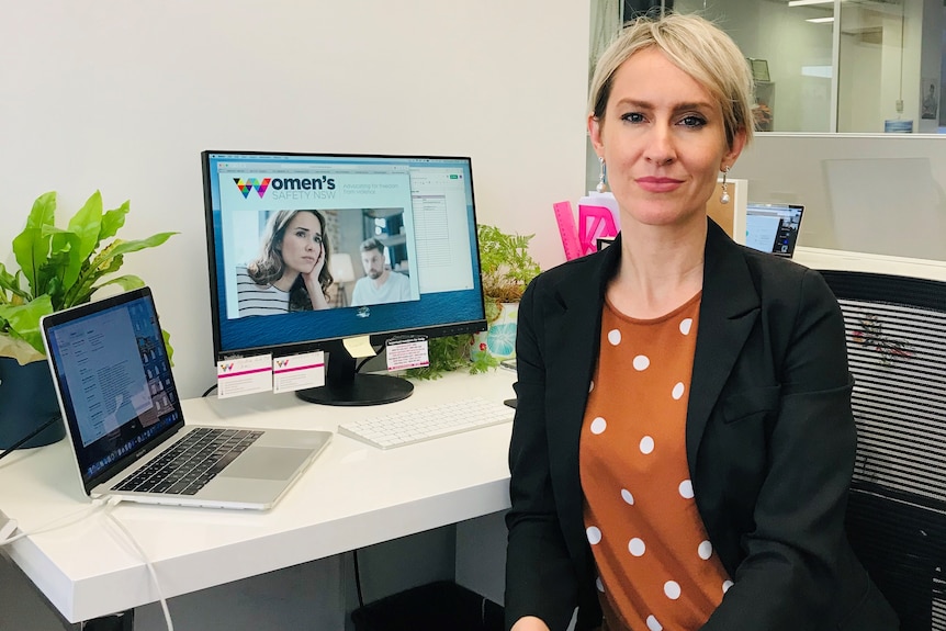 A woman sits in front of a computer