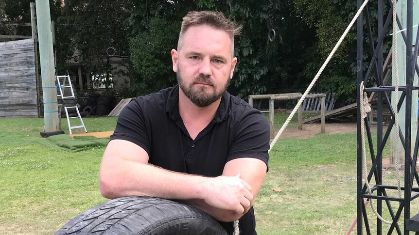 Shaun Barry leans on a car tyre.