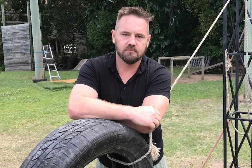 Shaun Barry leans on a car tyre.