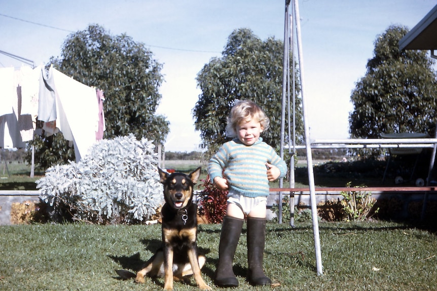 2 year old girl standing with dog