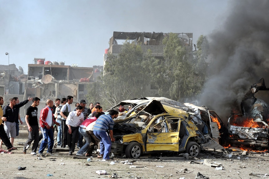 Residents rush to the scene of twin bombings in Damascus