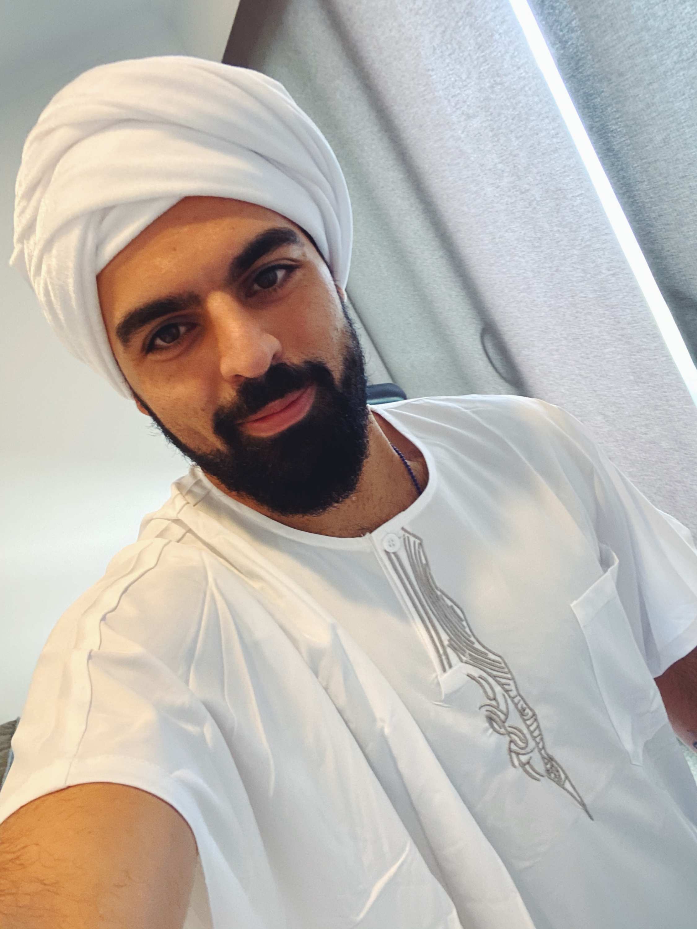 Ramtin poses for a selfie wearing a traditional Middle Eastern outfit.