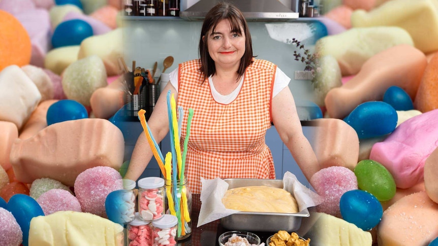 A woman in chequered apron stands in front of jars with musk sticks and lollies and an unbaked cake.