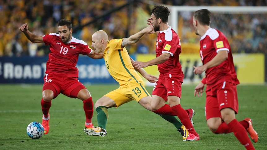 Aaron Mooy battles for the ball against Syria