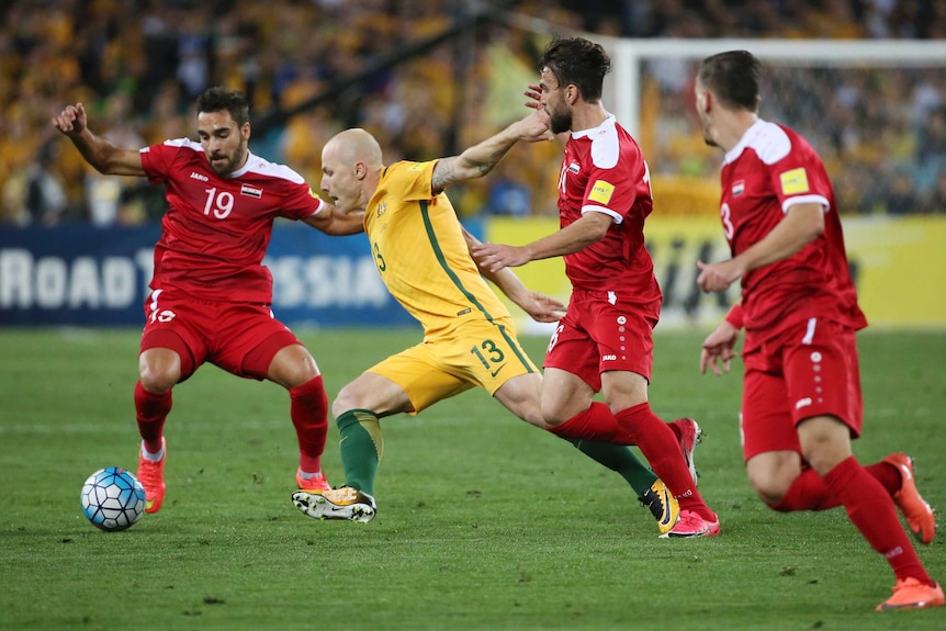 Aaron Mooy battles for the ball against Syria