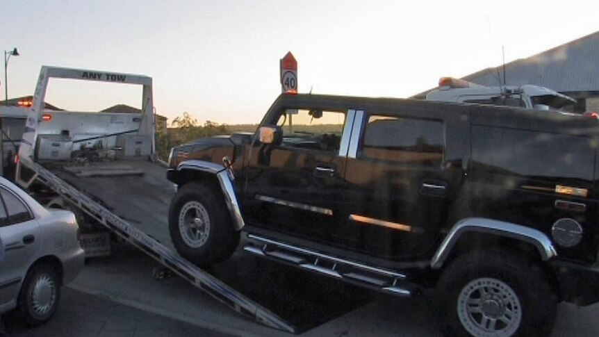 A Hummer vehicle is driven onto a tow truck