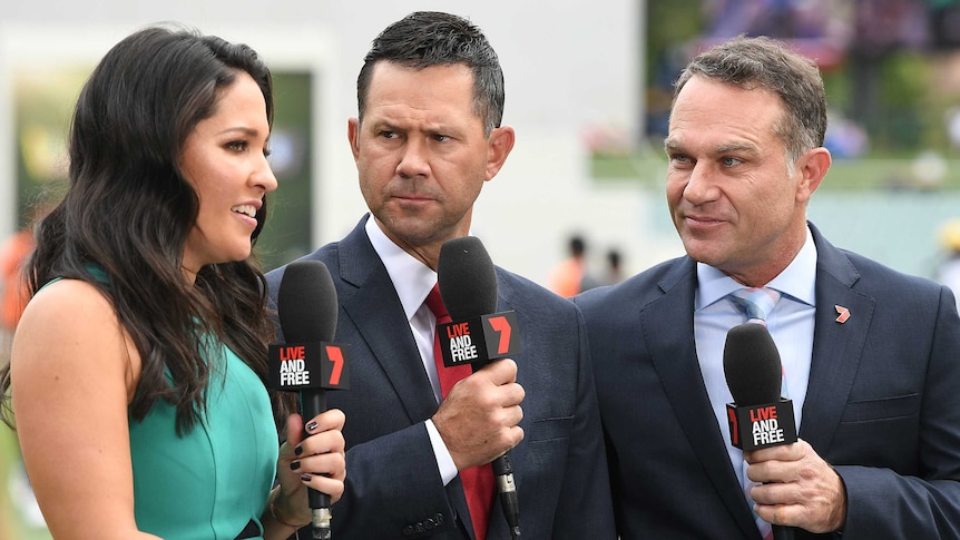 A grumpy-looking Ricky Ponting and smiling Michael Slater look at co-presenter Mel McLaughlin. All carry Seven-branded mics.