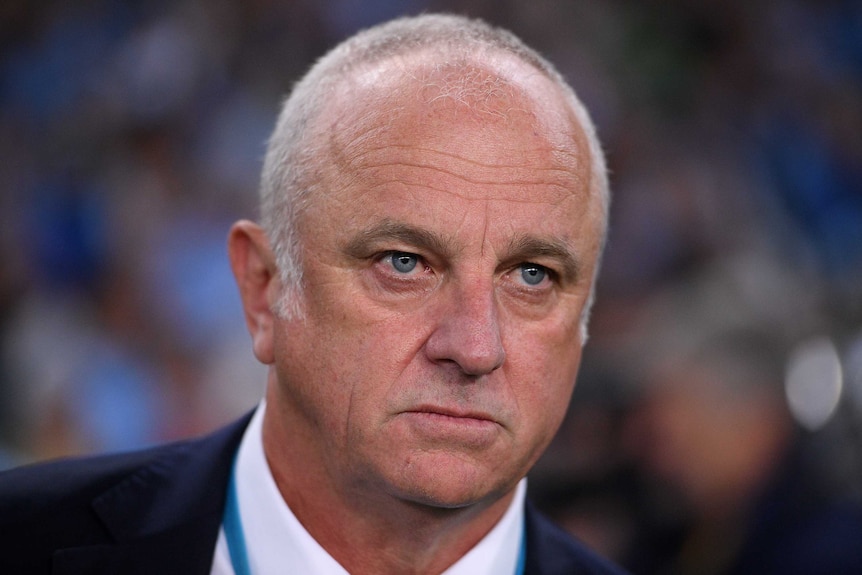Graham Arnold stares just off-camera with a blank expression. His brow is only slightly furrowed.
