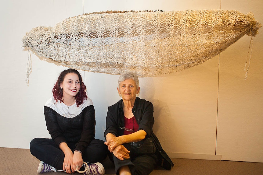 Pia Interlandi and Pam Thorne beneath Pam's shroud titled Fibre of my Being