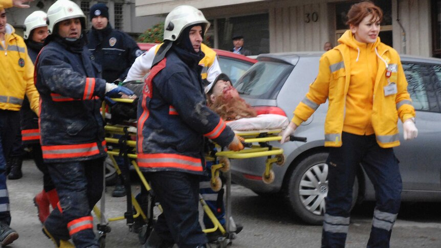Ambulance workers carry away a person injured in the blast at the US embassy in Ankara