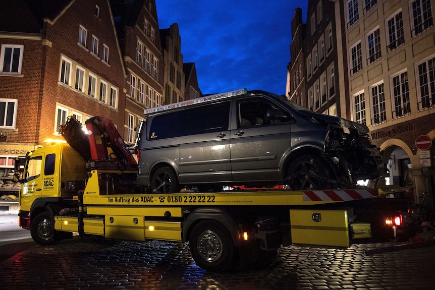 A damaged van sits on the platform of a truck in Muenster after the van crashed into people drinking outside a popular bar.