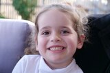 Arlo, brown hair, brown eyes, smiling, tight shot, wearing a white shirt.