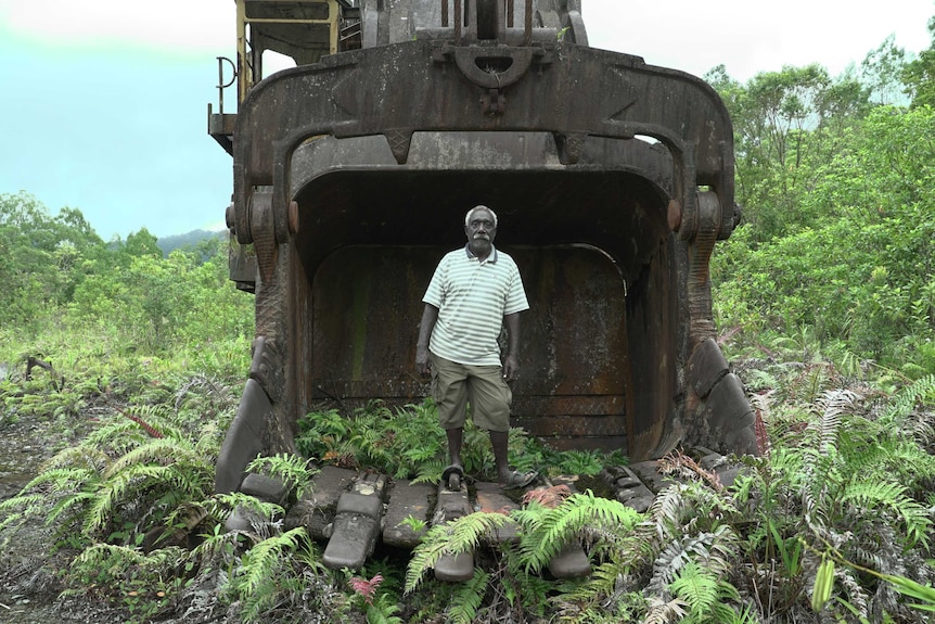 Philip Miriori's stands in a digger bucket.