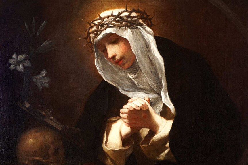 Painting of St Catherine of Siena, by artist Baldassare Franceschini, wearing crown of thorns and praying.