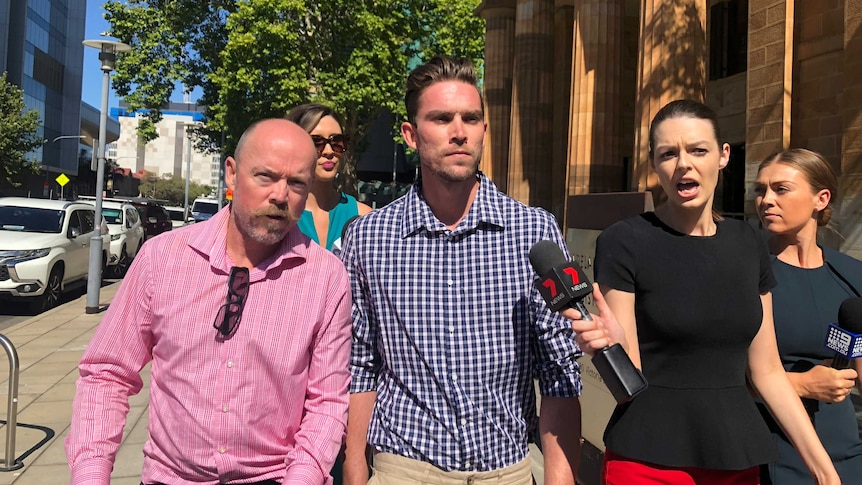 A man walks outside court surrounded by media personnel