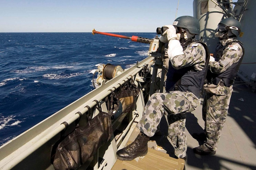 Two navy officers scan the horizon on HMAS Toowoomba