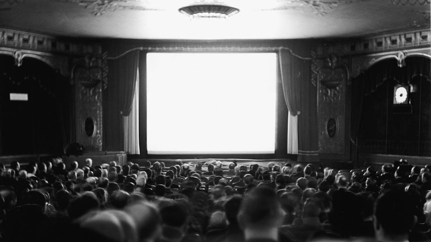 Audience watch the screen at the Newsreel Theatre on Broadway and 47th Street, New York, 1940.