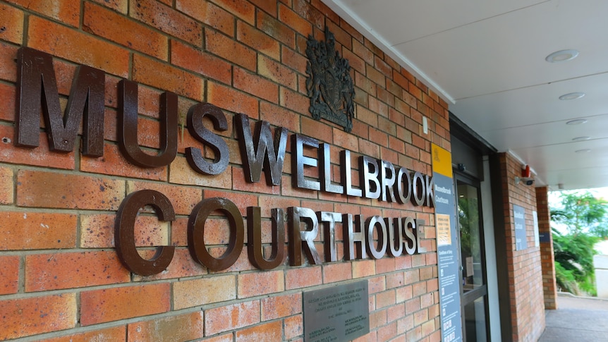 A close up shot of the words Muswellbrook Courthouse stuck to front of light-brown brick building.