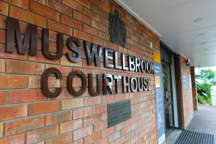 A close up shot of the words Muswellbrook Courthouse stuck to front of light-brown brick building.