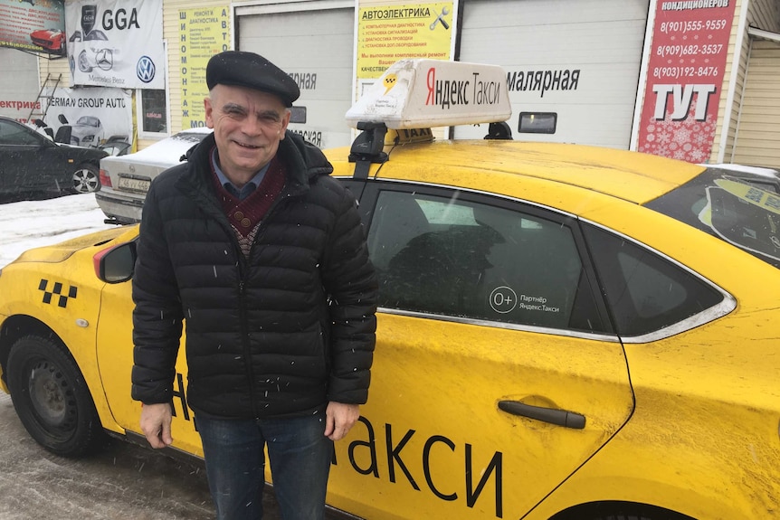 Alexander Yuryevich stands by his taxi in Moscow