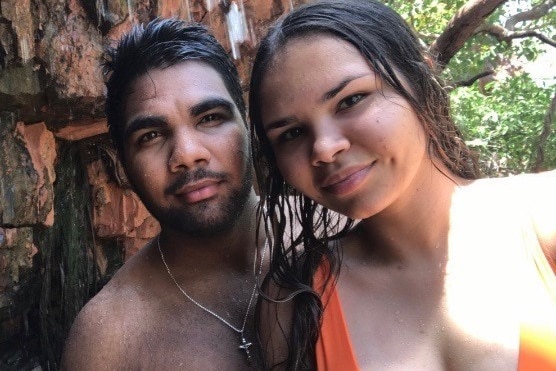 Portrait of Colen Nulgit and Shantelle Johnson smiling at camera, standing in front of tree