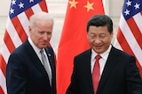 Xi Jinping shakes hands with Joe Biden in front of US and China flags