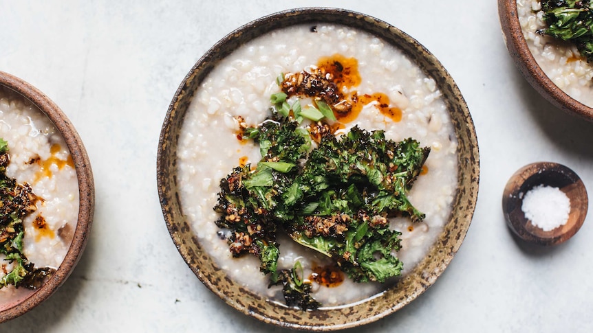 Three bowls of brown rice congee with a side of sea salt.