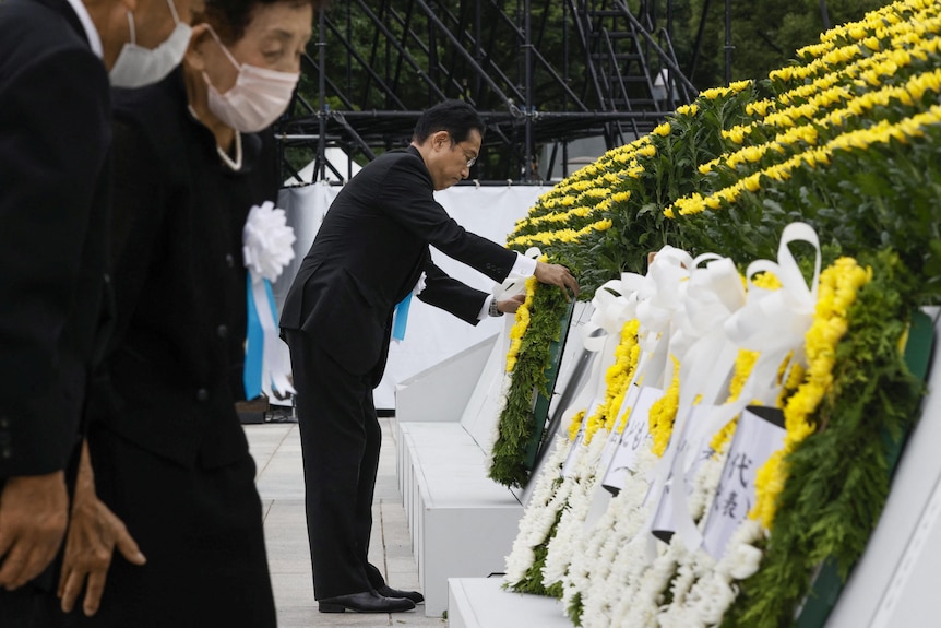 Премьер-министр Фумио Кисида возлагает венок к кенотафу.