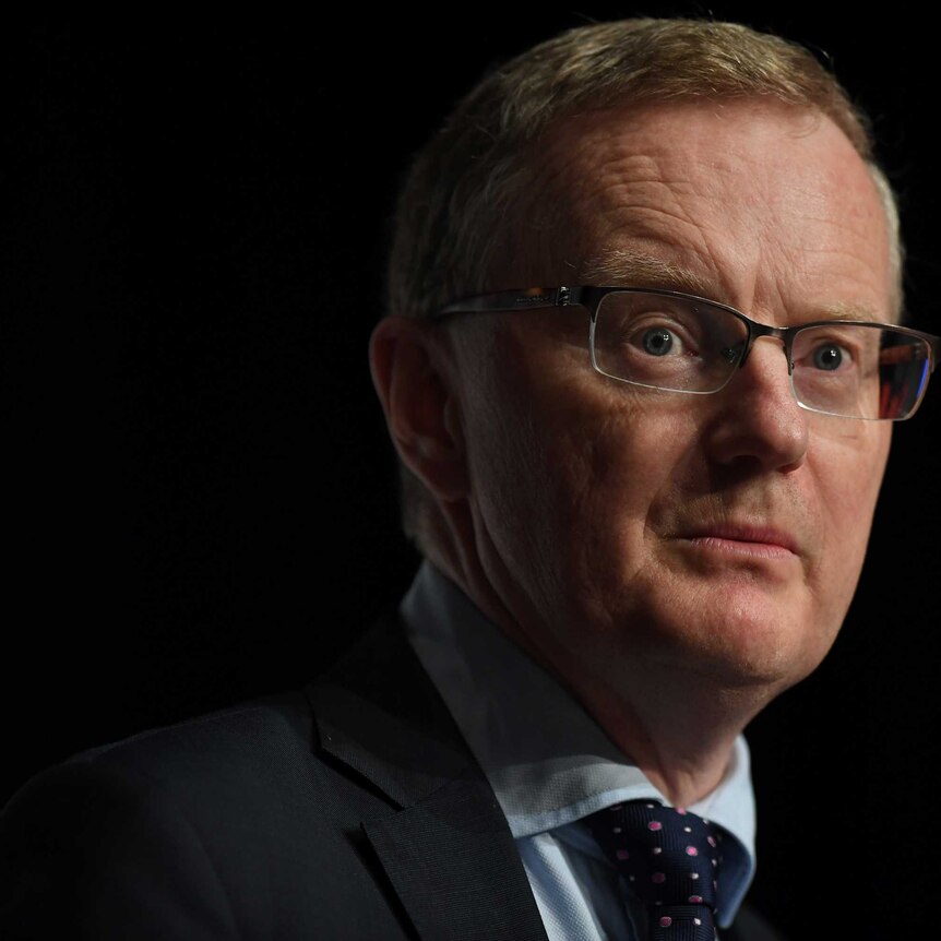 Reserve Bank of Australia governor Philip Lowe is pictured against a black background as he gives a speech.