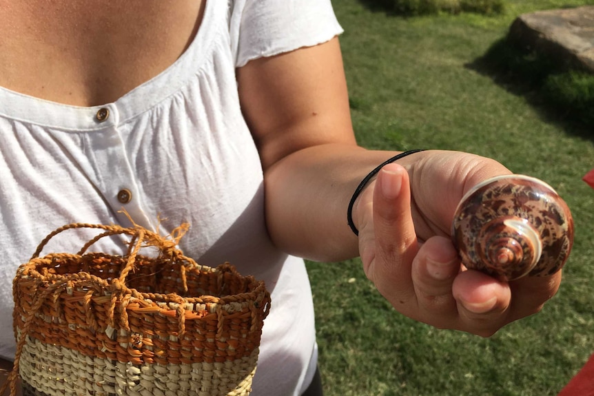 Visitor Service Guide Jessica Birk holds out a shell from the Barangaroo Reserve.