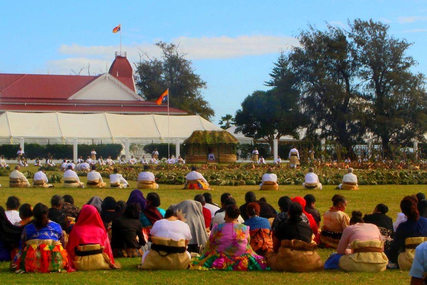 A large group of Tongans sit on a lawn.