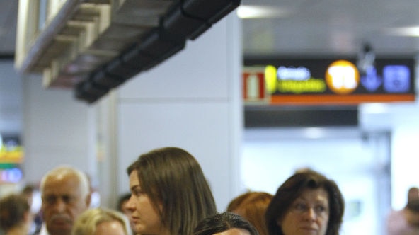 A passenger cries as she queues at the departures area in Madrid Airport