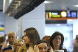A passenger cries as she queues at the departures area in Madrid Airport