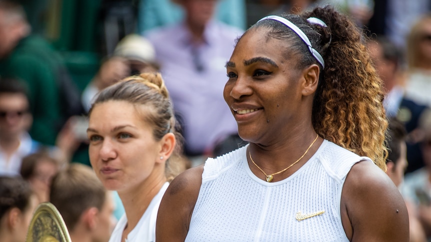 Serena Williams stands in front of Simona Halep