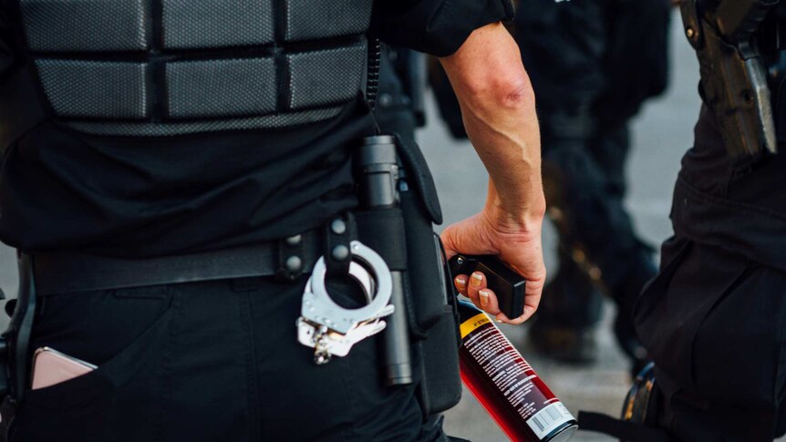 A police officer holds a can of pepper spray at a protest in Seattle in 2016.