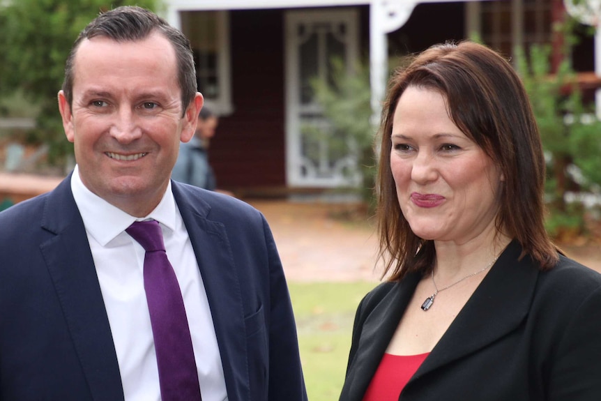 Tania Lawrence and Mark McGowan smile in front of a house in Mundaring.