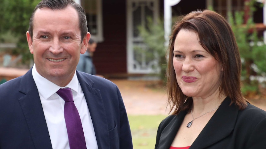 Tania Lawrence and Mark McGowan smile in front of a house in Mundaring.