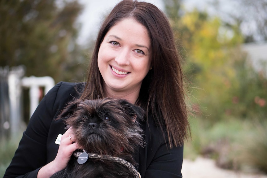 RSPCA Victoria head of operations Tegan McPherson holds a scruffy little black dog ready for a new home